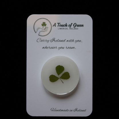 hand foraged shamrock encased in resin on a card with 'A Touch of Green' branding.