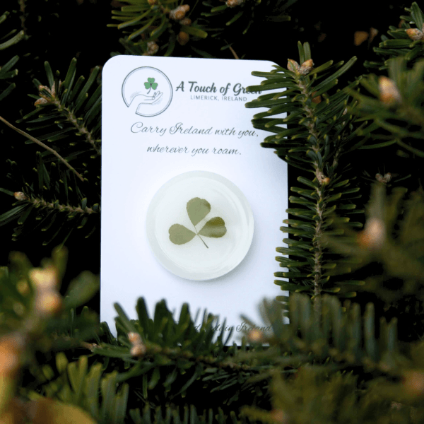 hand foraged shamrock encased in resin on a card with greenery in the background
