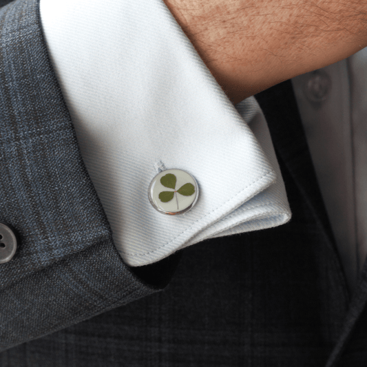 Silver cufflink with a hand foraged shamrock on a shirt 
